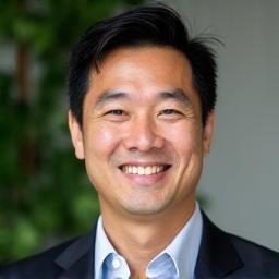Professional headshot of Alex Chen, a smiling man with short dark hair, wearing a casual golf polo shirt, looking approachable.